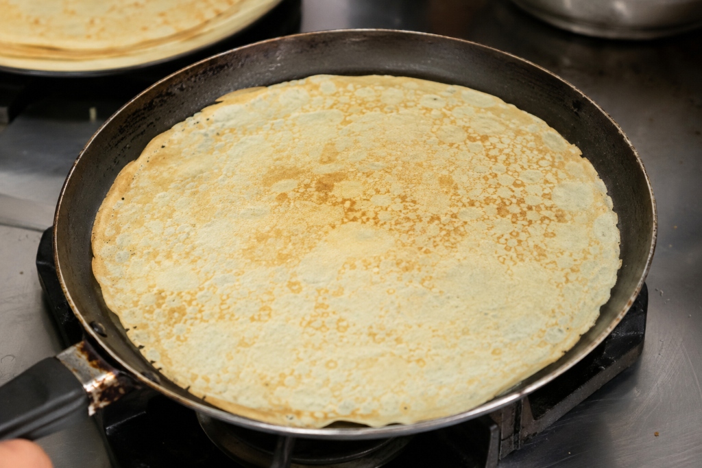 Fotografia real de um crepe fino na frigideira